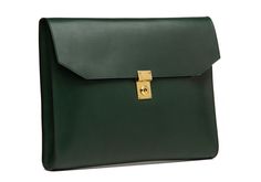 a green leather bag with a gold lock on the front and bottom flap, isolated against a white background