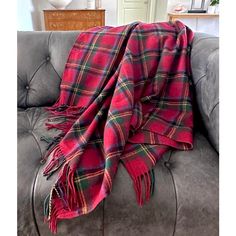 a red and black plaid blanket sitting on top of a gray couch in a living room