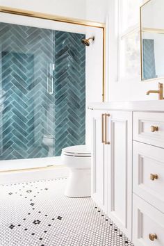 a bathroom with white cabinets and blue tiles on the floor, along with a red heart - shaped decoration