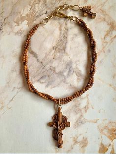 "Beautiful vintage Victorian French wooden cross necklace. This stunning necklace features an amazing vintage French hand-carved cross with carved cascading flowers.  The cross is antique, and is in remarkable, perfect condition. I added two strands of antique hand-carved tiny wooden beads to form the necklace. A small carved wood cross dangles from the chain.  The cross measures 2-5/8\" x 1- 3/8\". Pendant drop is 3-1/4\". Additional brass chain allows adjustability. The necklace measures  16\" Victorian Cross Necklace, Antique Handmade Cross Pendant Necklace, Vintage Cross Necklace Collectible, Vintage Crucifix Cross Necklace Gift, Wooden Cross Necklace, Carved Flowers, Cascading Flowers, Brown Cross-shaped Rosary With Wooden Beads, Victorian Pendants