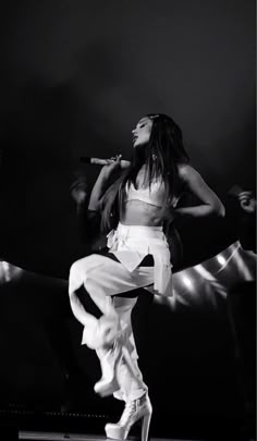 a woman standing on top of a stage with her legs spread out in the air