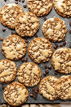 an overhead view of cookies with icing and chocolate chips on a baking sheet, surrounded by coffee beans