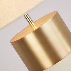 a gold lamp with a white shade on it