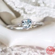 an engagement ring with a heart shaped blue topaz