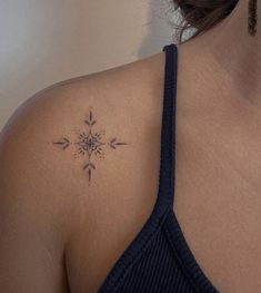 a woman's shoulder with a tattoo on it that has an arrow in the middle