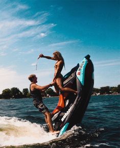 two people on a jet ski being pulled by a man in the water with an i love you sticker