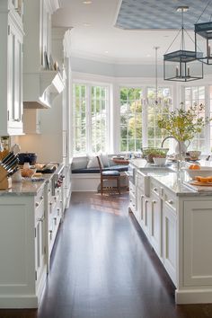 a kitchen filled with lots of white cabinets and counter top space next to a window