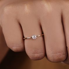 a woman's hand with a diamond ring on her finger, showing the middle finger