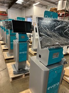 several computer monitors sitting on top of pallets in a warehouse with plastic covering them