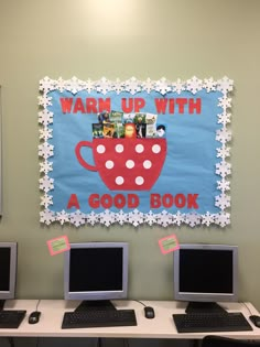 two laptops sitting on top of a desk next to a sign that says warm up with a good book