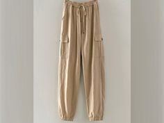 "Stay comfortable and stylish this summer with these premium quality mid rise jogger linen pants. Featuring an elastic waistband, adjustable drawstring, and cargo pockets, these pants are perfect for a beach vacation, lounge day, or resort cruise. Choose from the colors of Mint, Khaki, and White in sizes ranging from small to large. With real side pockets, you'll have a place to store your essentials while looking chic and fashionable. Upgrade your summer wardrobe with these must-have cargo line Summer Khaki Cargo Pants With Drawstring, Summer Comfortable Relaxed Fit Cargo Pants, Summer Linen Cargo Pants With Elastic Waistband, Casual Summer Cargo Pants With Drawstring, Summer Relaxed Fit Cargo Pants With Drawstring, Casual Linen Cargo Bottoms, Beige Linen Cargo Pants For Spring, Spring Beige Linen Cargo Pants, Summer Khaki Cargo Pants For Loungewear