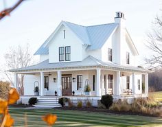 a large white house sitting on top of a lush green field