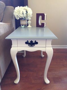 a small white table with flowers on it