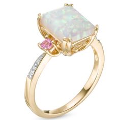 Fashioned In 10k Gold, This Three Stone Ring Features A 10.0 X 8.0mm Emerald-Cut Lab-Created Opal Center Stone Flanked On Either Side By Two Lab-Created Pink Sapphires With Diamond Accents Lining The Ring's Shank. Elegant Pink Opal Jewelry For Formal Occasions, Elegant Formal Pink Opal Jewelry, 14k Gold Pink Gemstone Jewelry, Pink Opal Ring With Accent Stones As Gift, Pink 14k Gold Jewelry With Gemstone Accents, Elegant Pink Opal Yellow Gold Jewelry, Elegant Pink Opal Ring, Pink Opal Gemstone Ring For Anniversary, Pink Diamond Ring With Birthstone For Formal Occasions