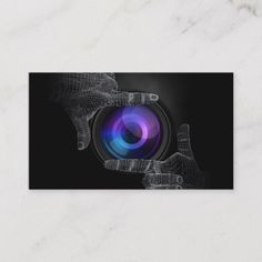 a business card with an image of a camera in the middle, and two hands holding it