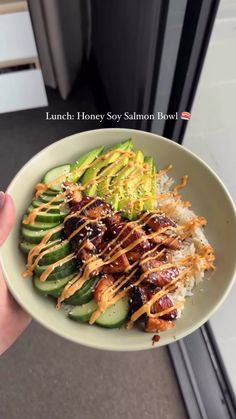 someone is holding a bowl with some food in it and the words, lunch honey soy salmon bowl