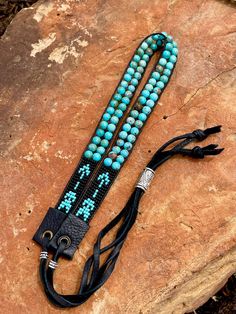 Hand loomed turquoise hatband in three different leather combinations. Sliding silver bead will allow this band to fit any hat style/adjustable! Made with: * Toho seed beads * Genuine Turquoise - 6mm (40 beads total) * Leather * Deer skin lace/suede leather * Silver beads Total length of band = 39 inches (circumference) Bohemian Beaded Bracelet With Adjustable Band, Adjustable Turquoise Beaded Artisan Bracelets, Western Style Adjustable Beaded Jewelry, Artisan Turquoise Beaded Bracelets Adjustable, Adjustable Southwestern Turquoise Hat Bands, Adjustable Turquoise Western Bracelet, Handmade Adjustable Western Bracelets, Southwestern Beaded Turquoise Hat Bands, Adjustable Blue Southwestern Hat Band