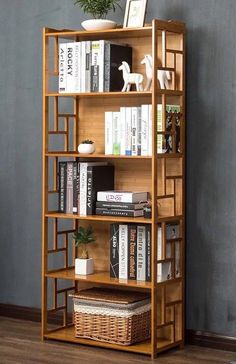 a wooden book shelf with books on top of it next to a potted plant