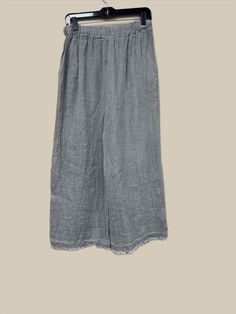 Indulge in luxury with these Button Detail Linen Pants. Made from premium Italian linen, these pants feature sophisticated button detailing, a flattering wide leg, and an elastic waist with drawstring for the perfect fit. With two front pockets and a distressed hem, these pants offer both style and comfort, making them a must-have for any elegant and cabin chic wardrobe. One Size (fits S-L) Linen Trousers With Button Closure, Wide Leg Linen Pants With Buttons, Relaxed Fit Loungewear Bottoms With Buttons, Wide Leg Loungewear Pants With Button Closure, Relaxed Fit Linen Pants With Buttons, Button-detail Loungewear Pants, Elegant Linen Bottoms With Buttons, Relaxed Fit Straight Pants With Buttons, Gray Bottoms With Button Closure For Spring