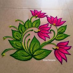 a flower design on the ground with green leaves and pink flowers in the center,