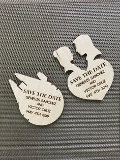 two wooden save the date magnets sitting on top of a piece of luggage