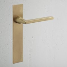 a brass colored door handle on a white wall