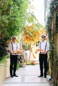 two men holding trays of food in their hands while standing next to each other