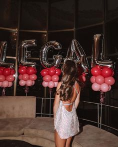 a woman standing in front of balloons that spell out the word'e4c '