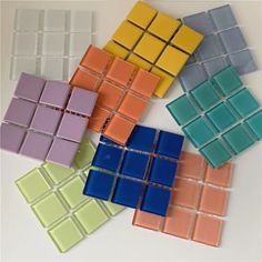 several different colored glass tiles on a white surface