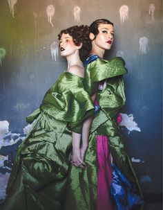 two women in green dresses standing next to each other