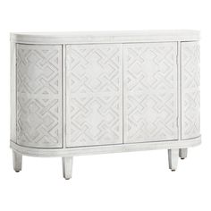 a white cabinet with an intricate design on the front and side panels, it has two doors