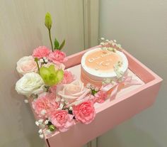 a pink box with flowers and a cake on it