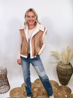 Camel Tan Suede Vest with Sherpa Trim Upgrade your winter wardrobe with our Camel Tan Suede Vest with Sherpa Trim. This chic vest is perfect for a stylish snow day outfit, offering a luxurious look and feel that will make you stand out. The soft suede material in a rich camel tan color is complemented by plush fur trim at the edges, giving it a high-end, sophisticated vibe. With a zipper front and side pockets, this vest combines practicality with elegance. The relaxed fit ensures comfort, makin Beige Winter Vest Outerwear, Beige Winter Vest For Cold Weather, Cozy Winter Vest For Cold Weather, Beige Vest For Winter Cold Weather, Beige Vest For Cold Weather In Winter, Beige Vest For Cold Weather And Winter, Trendy Brown Winter Vest, Brown Winter Vest Outerwear, Chic Brown Winter Vest