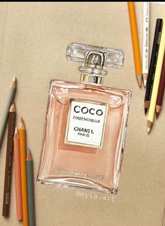 a bottle of perfume sitting on top of a table next to pencils and markers