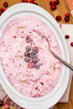 a white bowl filled with cranberry fluff on top of a wooden table