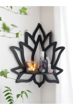 a candle is lit on a shelf in the shape of a lotus with candles inside