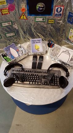 there is a keyboard and headphones on top of a round table with many stickers