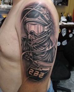 a man with a motorcycle helmet and number 99 tattoo on his arm