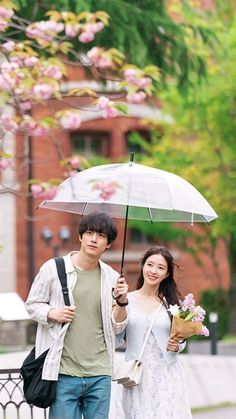 a man and woman walking down the street under an umbrella with flowers in their hand