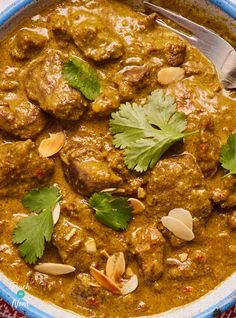 a close up of a bowl of food with meat and vegetables in it, garnished with cilantro