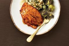 a white plate topped with chicken, brussel sprouts and rice