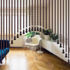 a room with a blue chair and some beads hanging from the ceiling