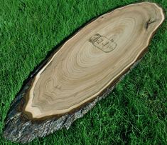 a piece of wood that has been cut in half on some green grass and is laying on the ground