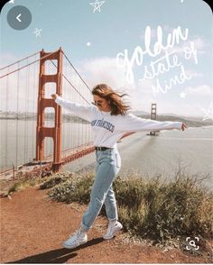 a woman is dancing in front of the golden gate bridge with her arms spread out