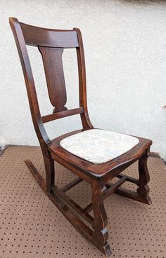 a wooden rocking chair sitting on top of a floor