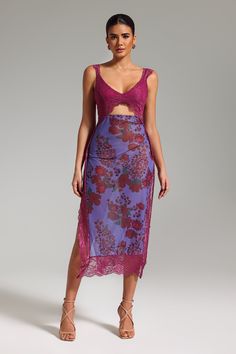 a woman wearing a purple dress with floral print on the skirt and pink crop top