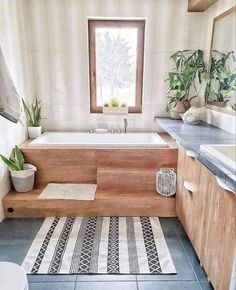 a bath tub sitting next to a window in a bathroom