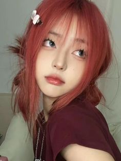 a young woman with red hair and flower in her hair is looking at the camera