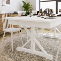 a white table and chairs in a room with a rug on the floor next to it