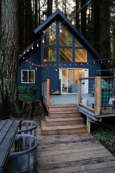 a small cabin in the woods with stairs leading up to it